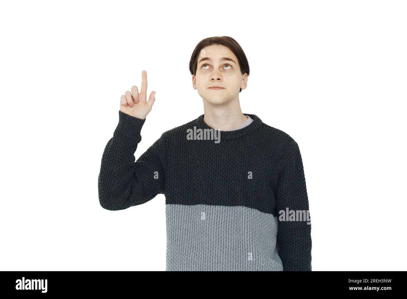 Clever young man in black sweater pointing up on white background Stock Photo