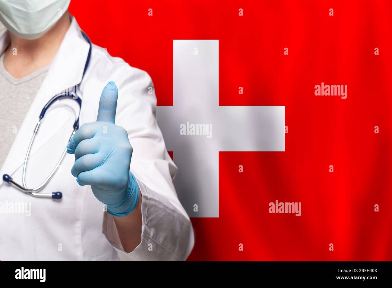 Swiss doctor's hand showing thumb up positive gesture on flag of