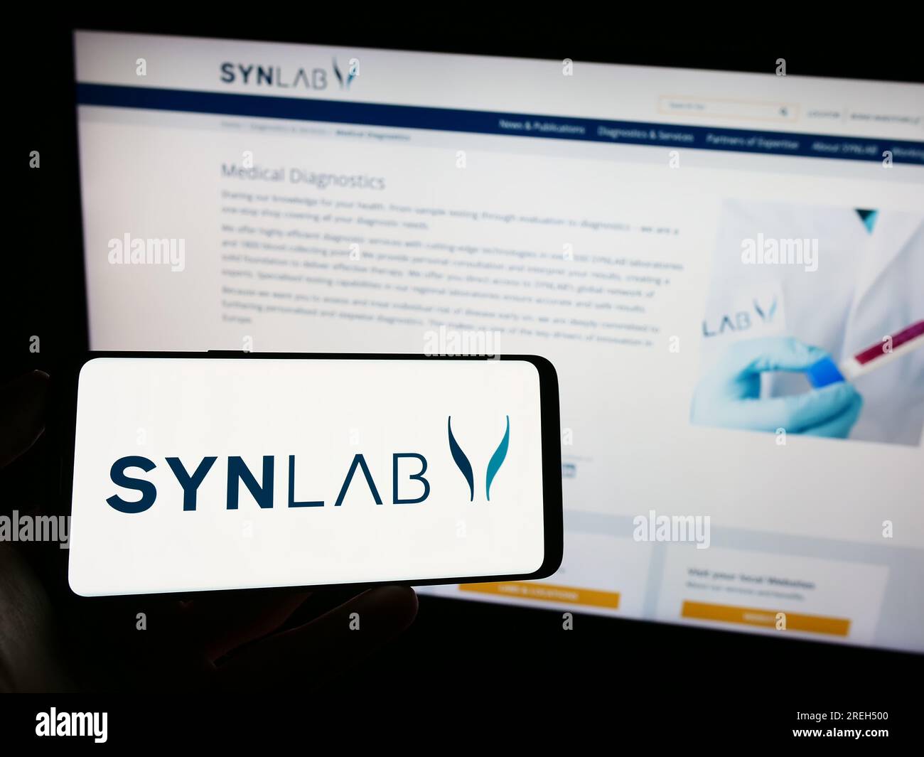 Person holding mobile phone with logo of medical diagnostics company SYNLAB  Group on screen in front of business web page. Focus on phone display Stock  Photo - Alamy