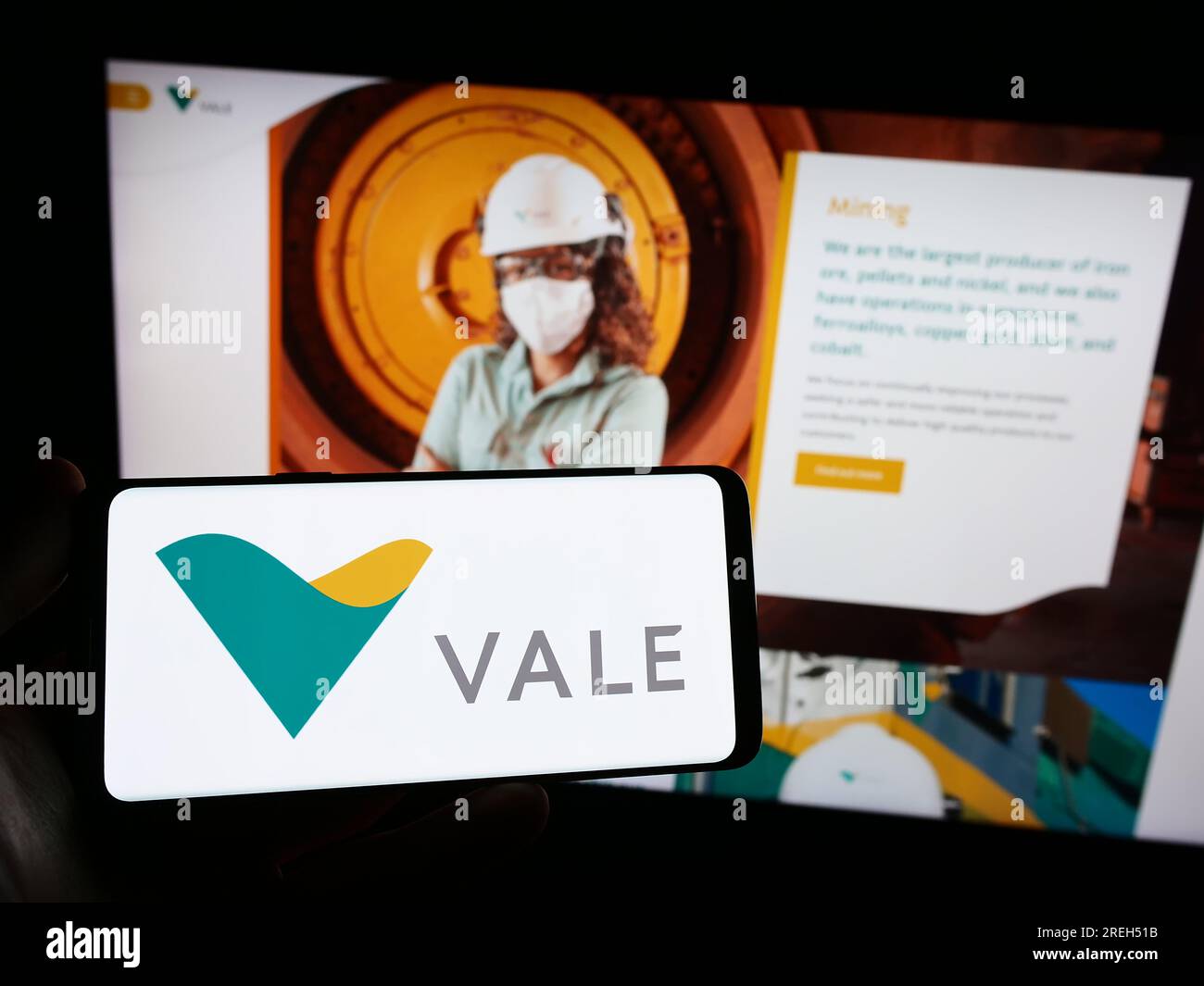 Person holding smartphone with logo of Brazilian mining company Vale S.A. on screen in front of