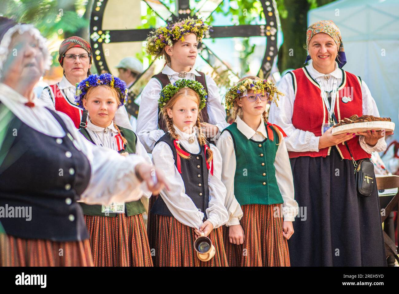 Group of adults and children in traditional clothes playing and singing on the stage during XXVII Nationwide Latvian Song and XVII Dance Festival Stock Photo