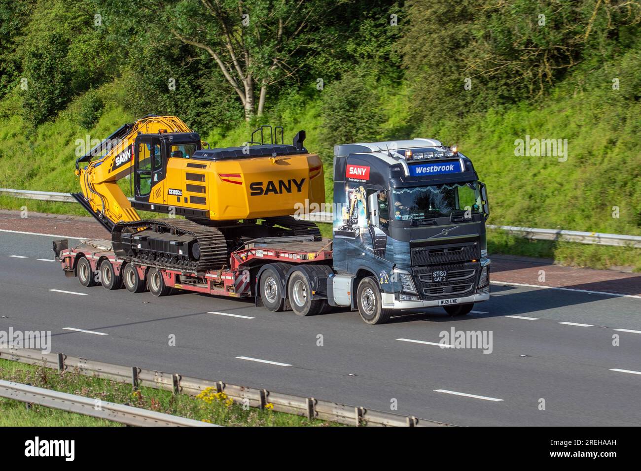 Peter driving Westbrook Commercials Ltd, Volvo FH. SANY SY305C tracked construction machinery manufacturers excavator;  travelling on the M6 motorway in Greater Manchester, UK Stock Photo