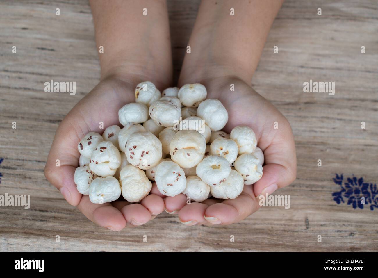 Makhana or foxnut in hand with brown background Stock Photo