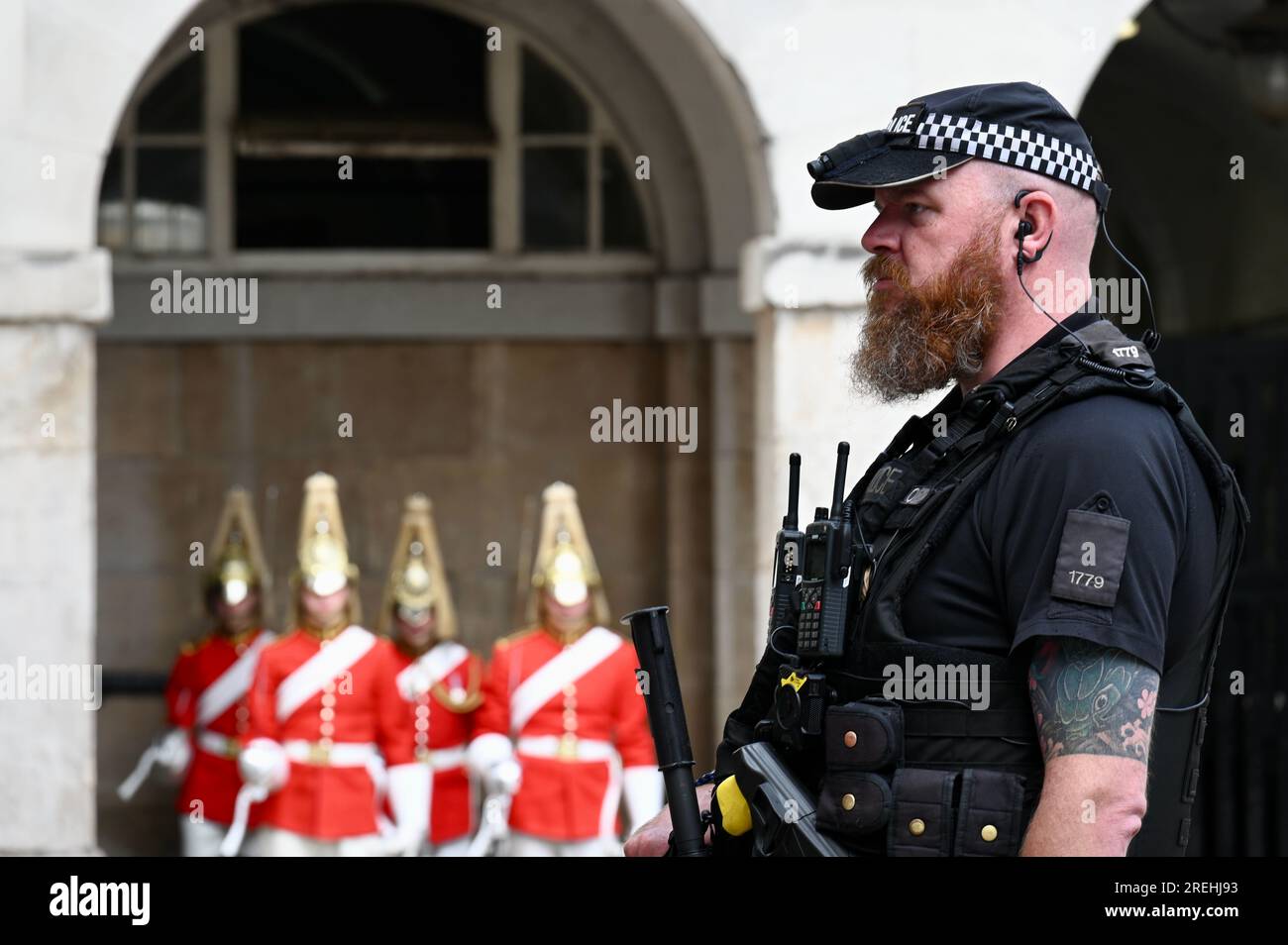 Armed Police Officer protecting the Changing of the King's Life Guard , Horse Guards Parade, Whitehall, London, UK Stock Photo