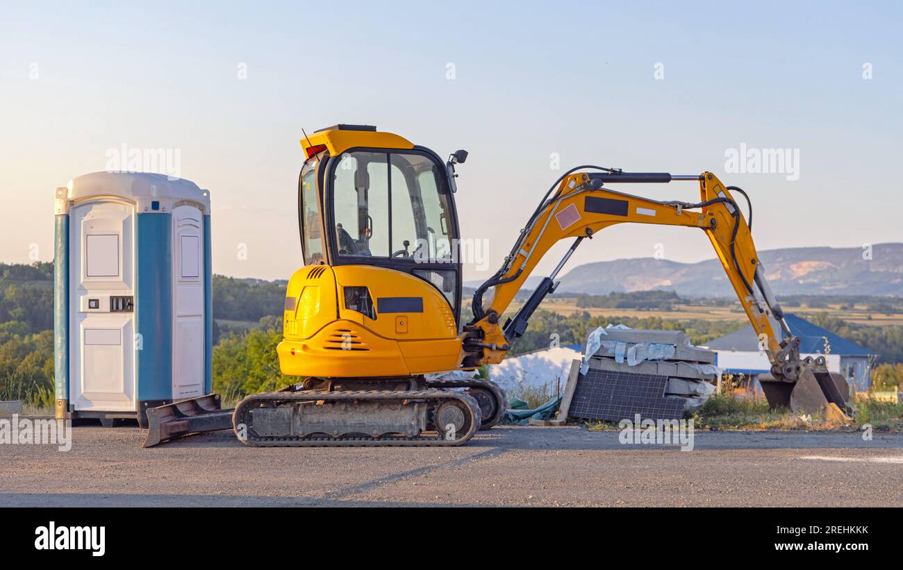 Portable Toilet Cabin and Mini Excavator Machine at Highway ...