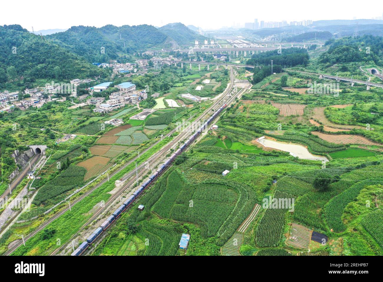 (230728) -- GUIYANG, July 28, 2023 (Xinhua) -- This aerial photo taken on July 28, 2023 shows the first direct China-Central Asia freight train from Dulaying international land-sea logistics port leaving Dulaying Station in Guiyang, southwest China's Guizhou Province. A cargo train left Dulaying international land-sea logistics port on Friday for Almaty of Kazakhstan, marking the launch of the first direct China-Central Asia rail-road intermodal freight train service from Guiyang. About 1,300 tonnes of agricultural products will be transported from Kazakhstan to Guiyang on the return journe Stock Photo