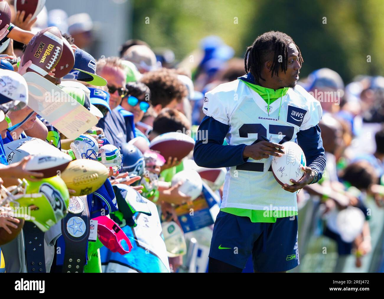 Seattle Seahawks cornerback Riq Woolen signs a football for a fan ...