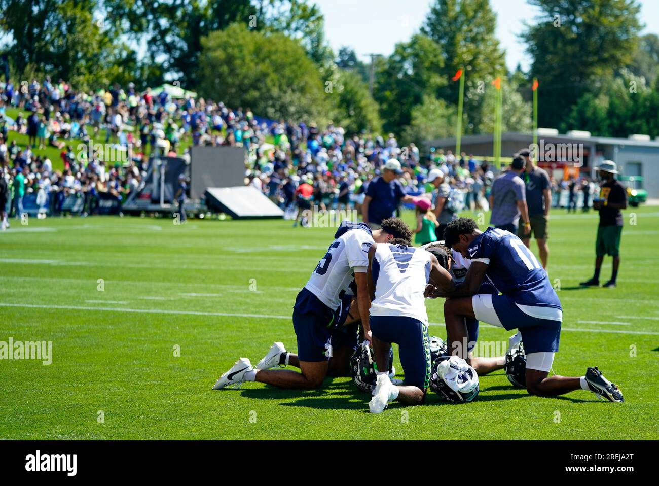 Members of the Seattle Seahawks, including free safety Joey Blount (35),  left, and wide receiver Matt Landers (17), right, take a knee to pray after  the NFL football team's training camp, Wednesday,