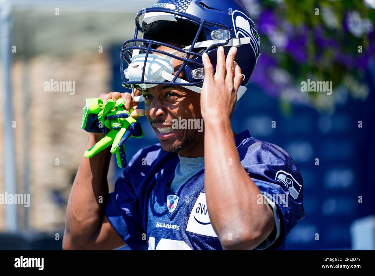 Seattle Seahawks wide receiver Tyler Lockett puts on his helmet as he walks  out to the field during the NFL football team's training camp Thursday,  July 27, 2023, in Renton, Wash. (AP