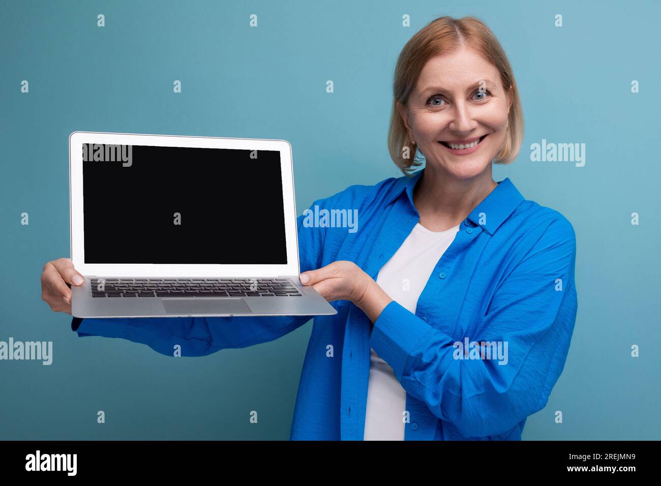 50s middle aged business woman showing laptop screen with mockup on ...