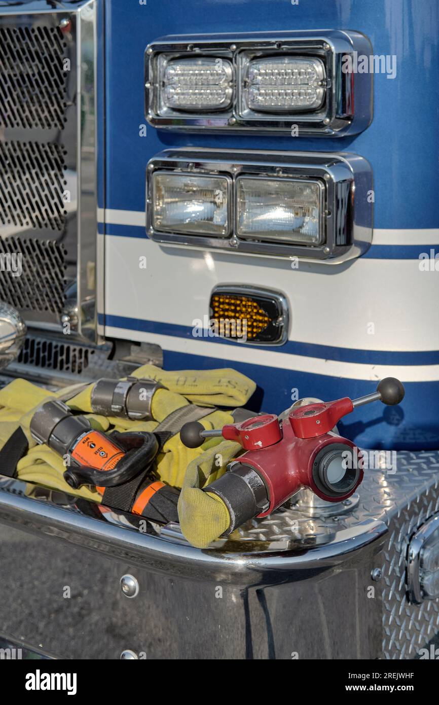 Hoses and valves on front bumper of a blue fire engine pumper truck. Stock Photo