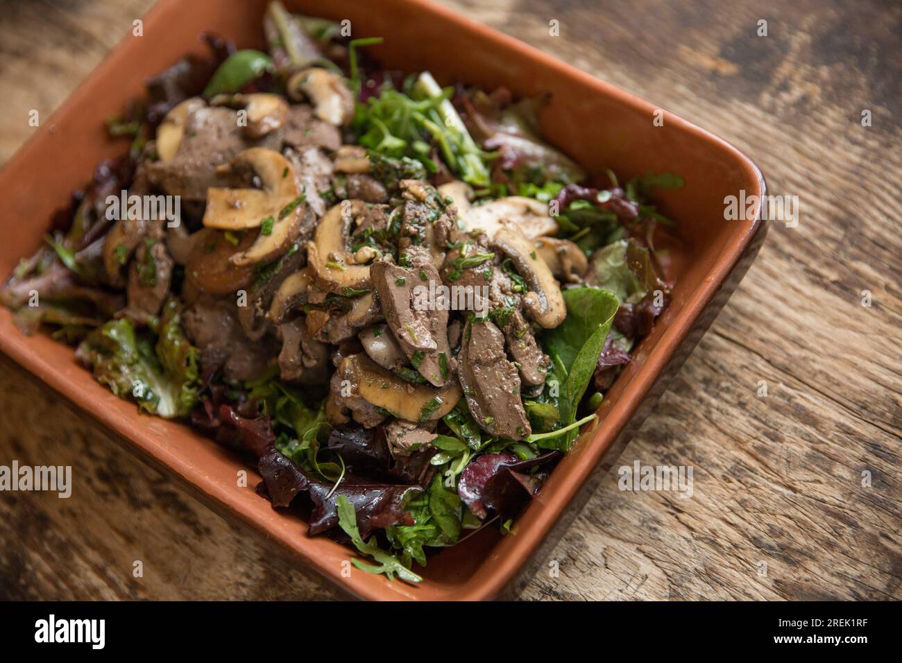 British chicken livers that have been fried and served with chestnut mushrooms imported from Poland, parsley from Germany, basil from Ethiopia and tar Stock Photo