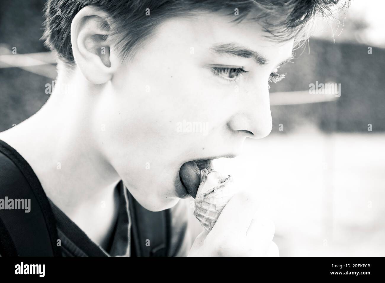 Black and white shot of a teenage boy eating an ice cream Stock Photo ...