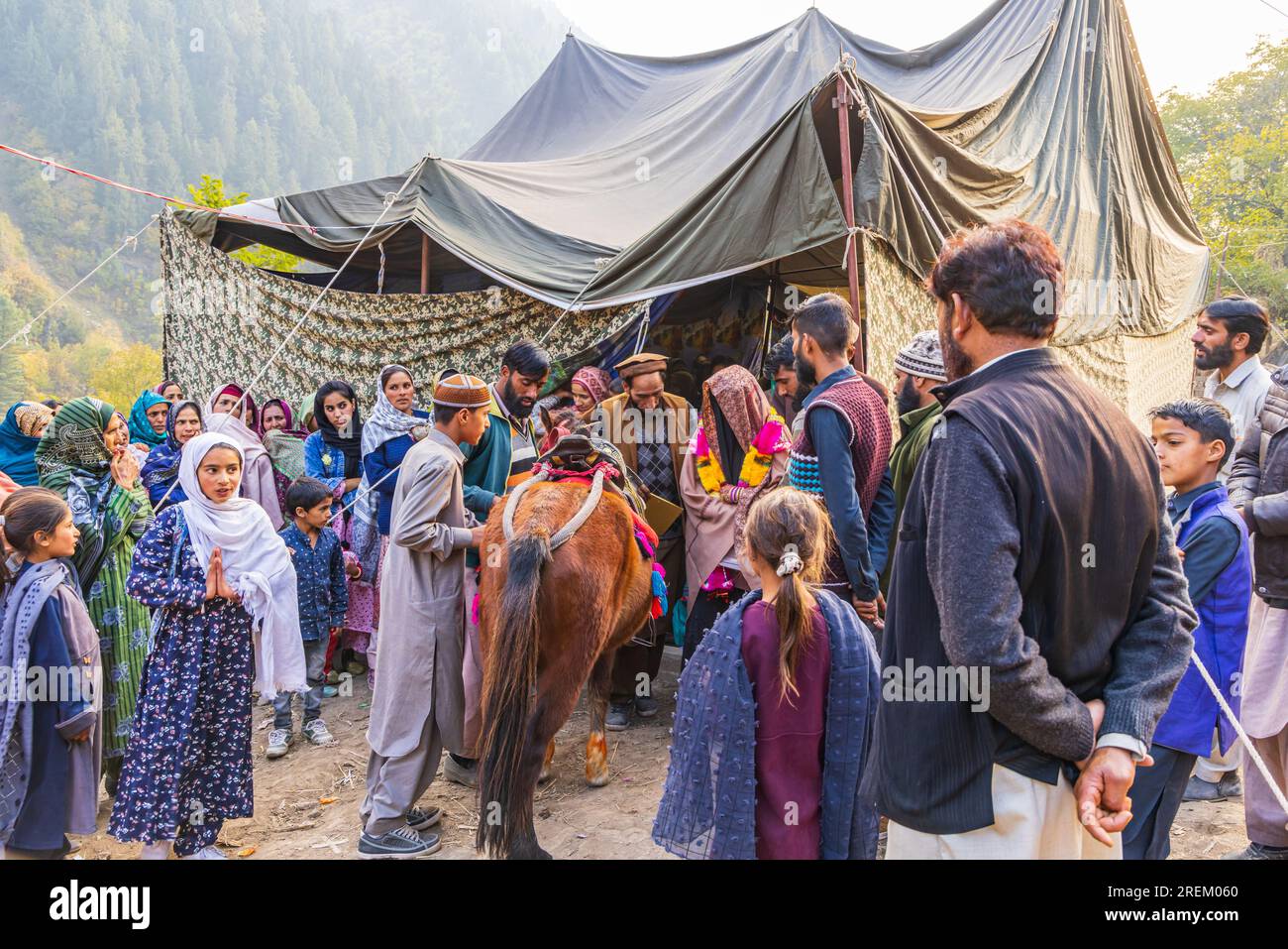 Kangan, Jammu and Kashmir, India. October 27, 2022. A young bride in a black veil getting on a horse at a village wedding in Jammu and Kashmir. Stock Photo