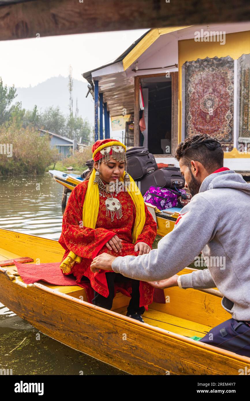 Rainawari, Srinagar, Jammu and Kashmir, India. November 2, 2022. Man preparing a woman for a portrait in boat at Dal Lake. Stock Photo