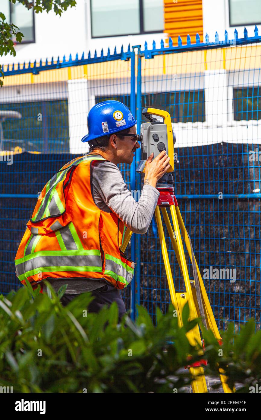 Survey technician using a laser theodolite on a construction site in Vancouver Canada Stock Photo