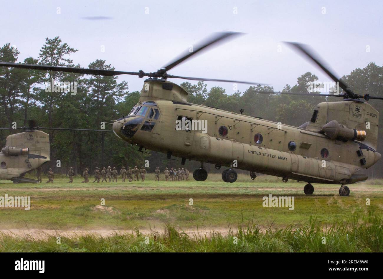 Soldiers with the 78th Training Division perform unboarding operations with two Boeing CH-47 Chinook crews assigned to the 5-159th General Service Aviation Battalion from Fort Eustis, Virginia, as part of warrior exercise (WAREX) 2023 on Joint Base Mcguire-Dix-Lakehurst, July 24, 2023. Soldiers with the 78th seized the rare opportunity to work with an available aviation unit to sharpen their skills and maintain the combat readiness of U.S. Army Reserve Soldiers. (This image was cropped, color and exposure edited to enhance the subject) (U.S. Army Reserve Photo by Spc. Jeremy Price) Stock Photo