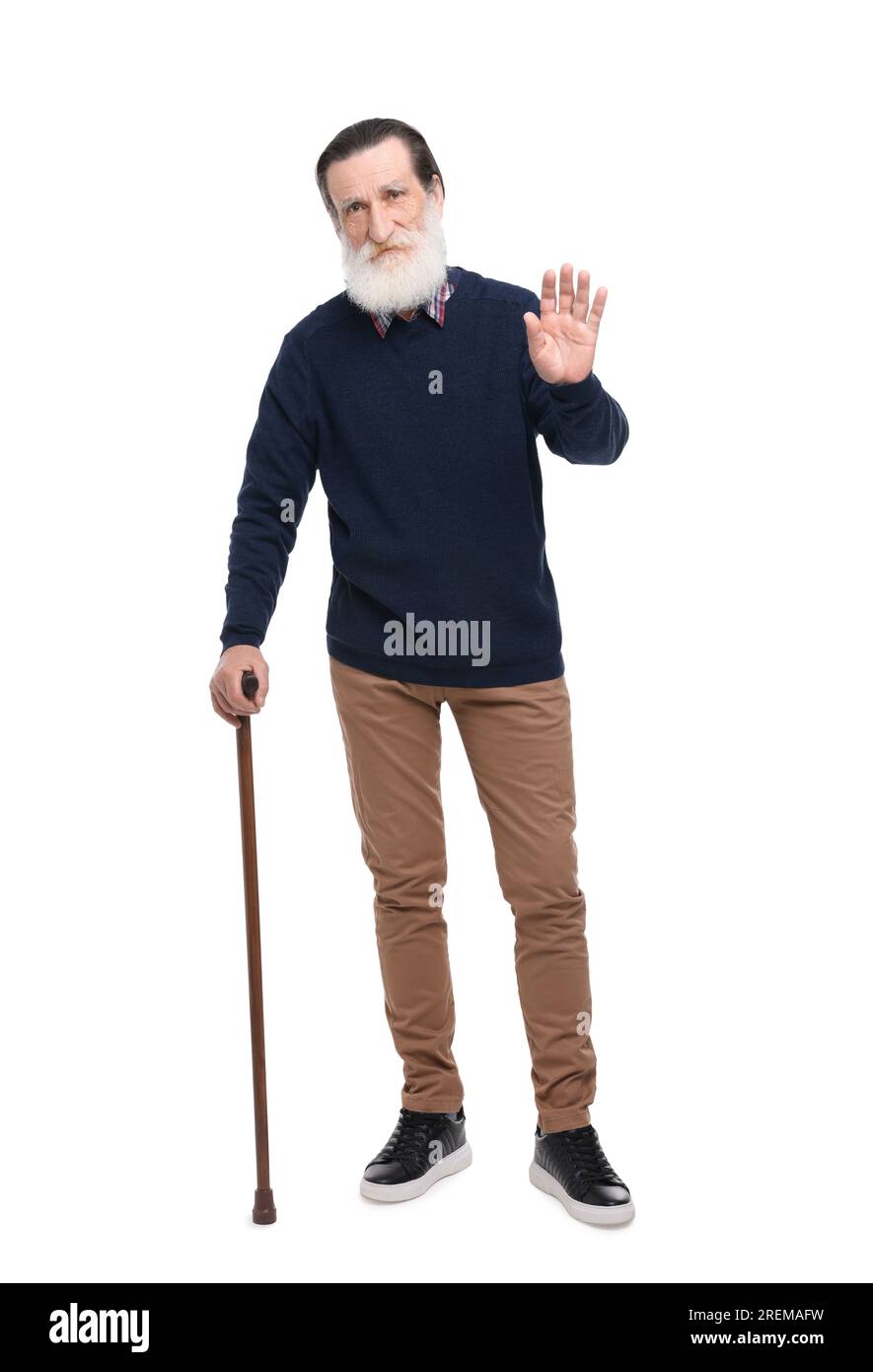 Senior man with walking cane waving on white background Stock Photo - Alamy