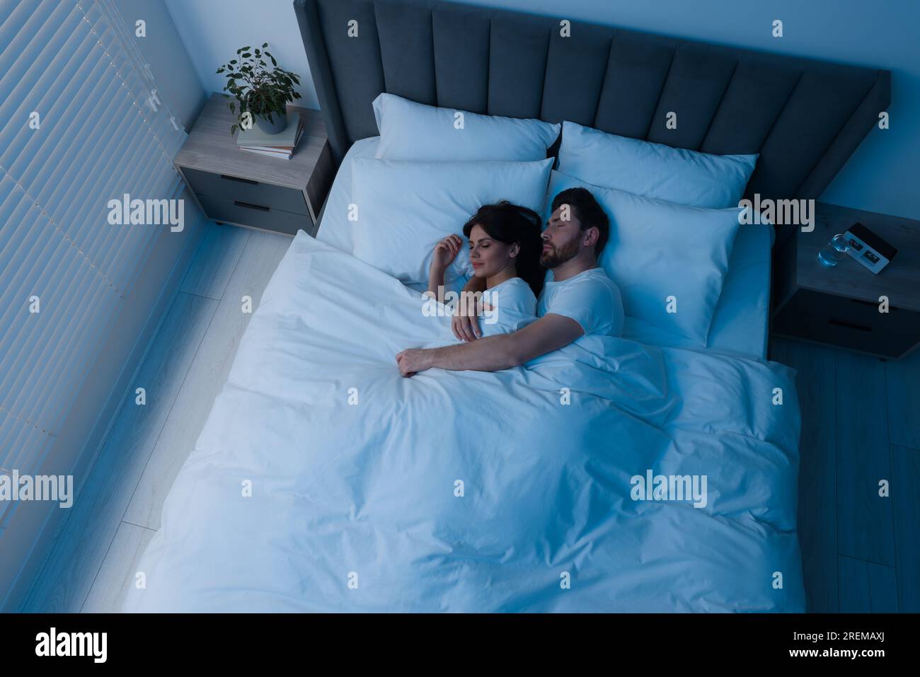 Lovely couple sleeping together in bed at night, top view Stock Photo ...