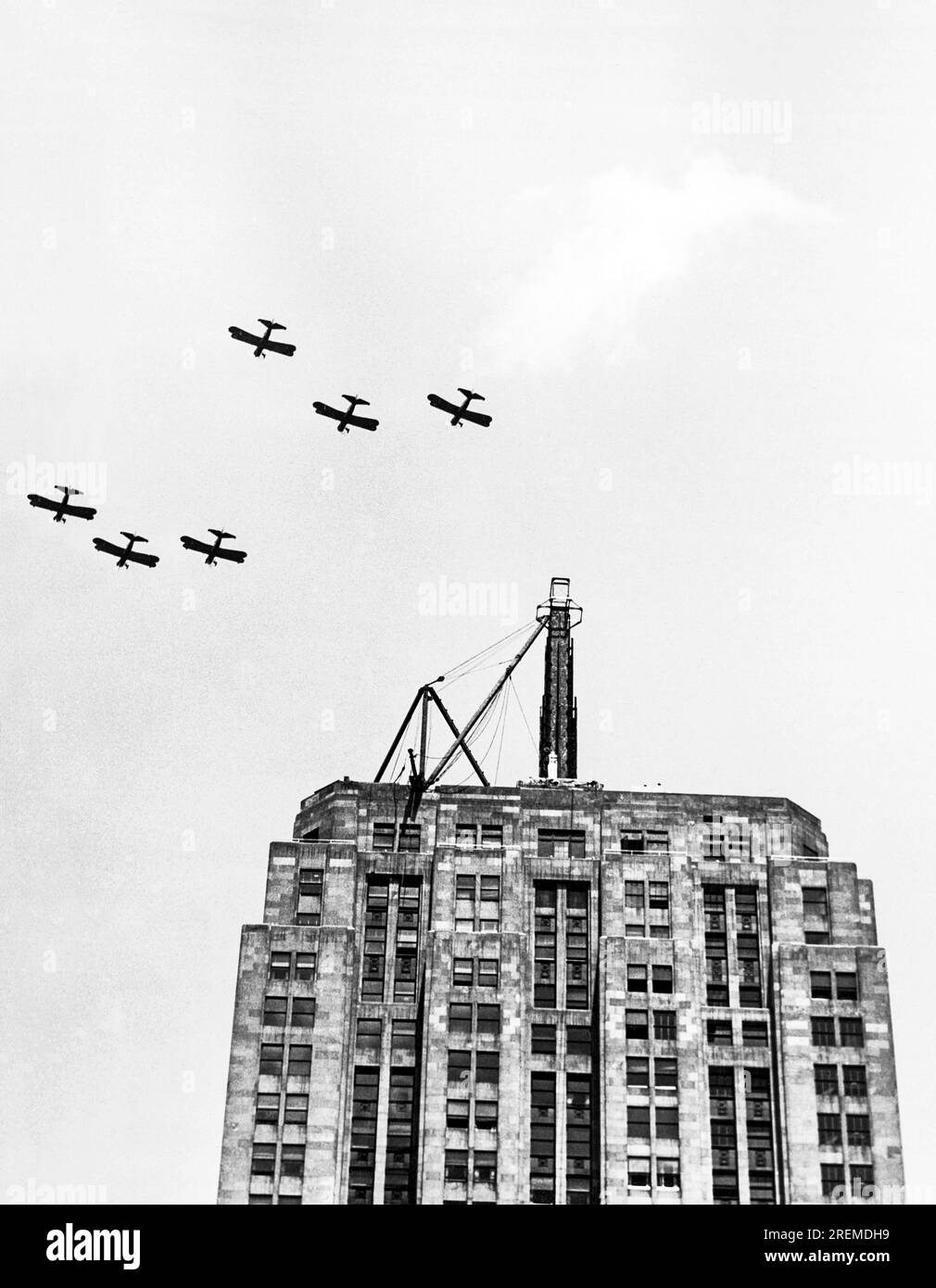 Chicago, Illinois:  July 9, 1930 Six U.S. Army planes fly in formation over the Palmolive building in salute to the Lindbergh Beacon under construction on the top of the building. It will soon be dedicated as the largest and most powerful beacon in the world, having 2 billion candle power and able to  throw a light for 500 miles. Stock Photo