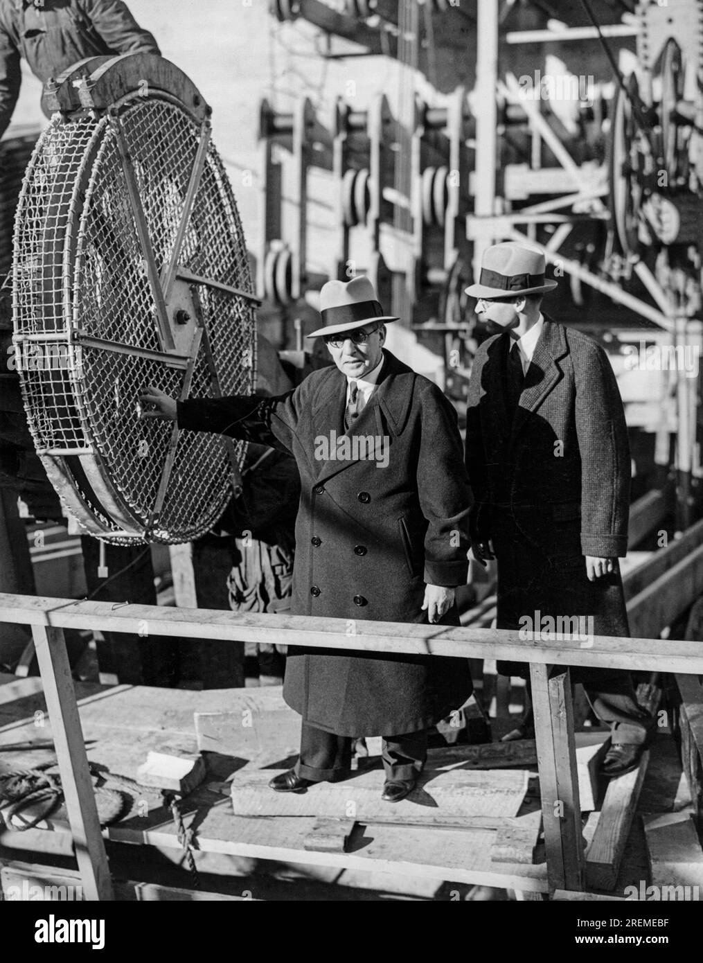 San Francisco, California:   1935 Chief Engineer and builder of the Golden Gate Bridge, Joseph Strauss, and Assistant Chief Engineer William Payne, discuss the details of the bridge as the first string of wire was released and sent out across the space where the bridge will be built. Stock Photo