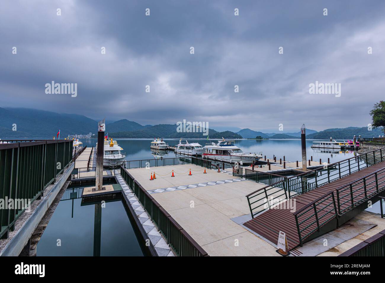 The morning view over Sun Moon Lake Marina in Taiwan is breathtaking, with calm waters reflecting the vibrant sunrise, surrounded by lush green mounta Stock Photo