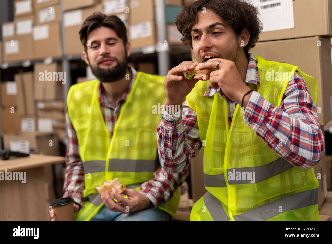 Group of manual workers in reflection vests during lunch break at