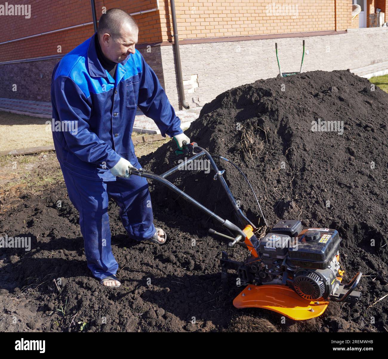 A man works in a vegetable garden in early spring. Digs the ground ...