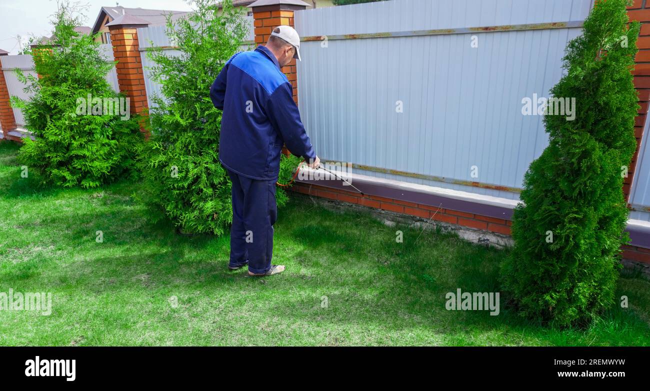 A man works in the garden, spraying weeds from a sprayer Stock Photo ...
