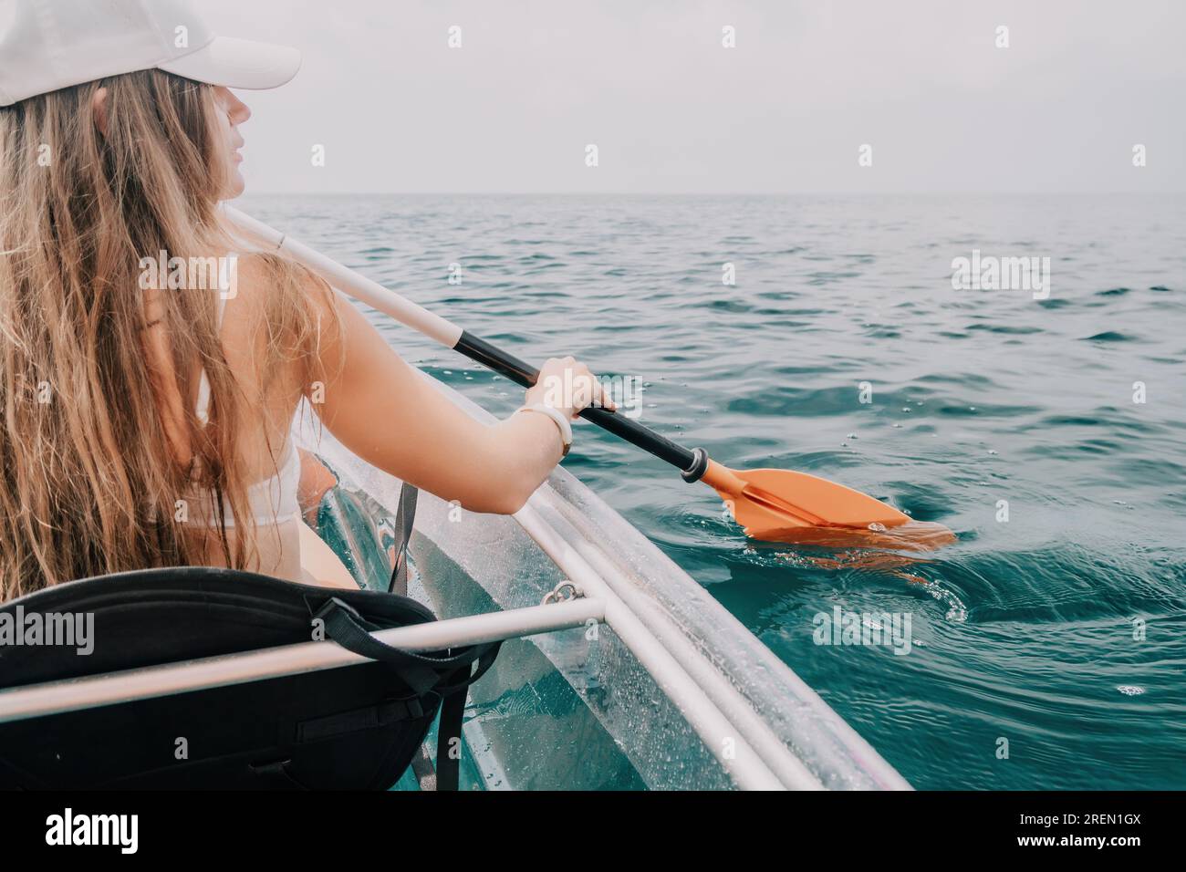 Woman in kayak back view. Happy young woman with long hair floating in