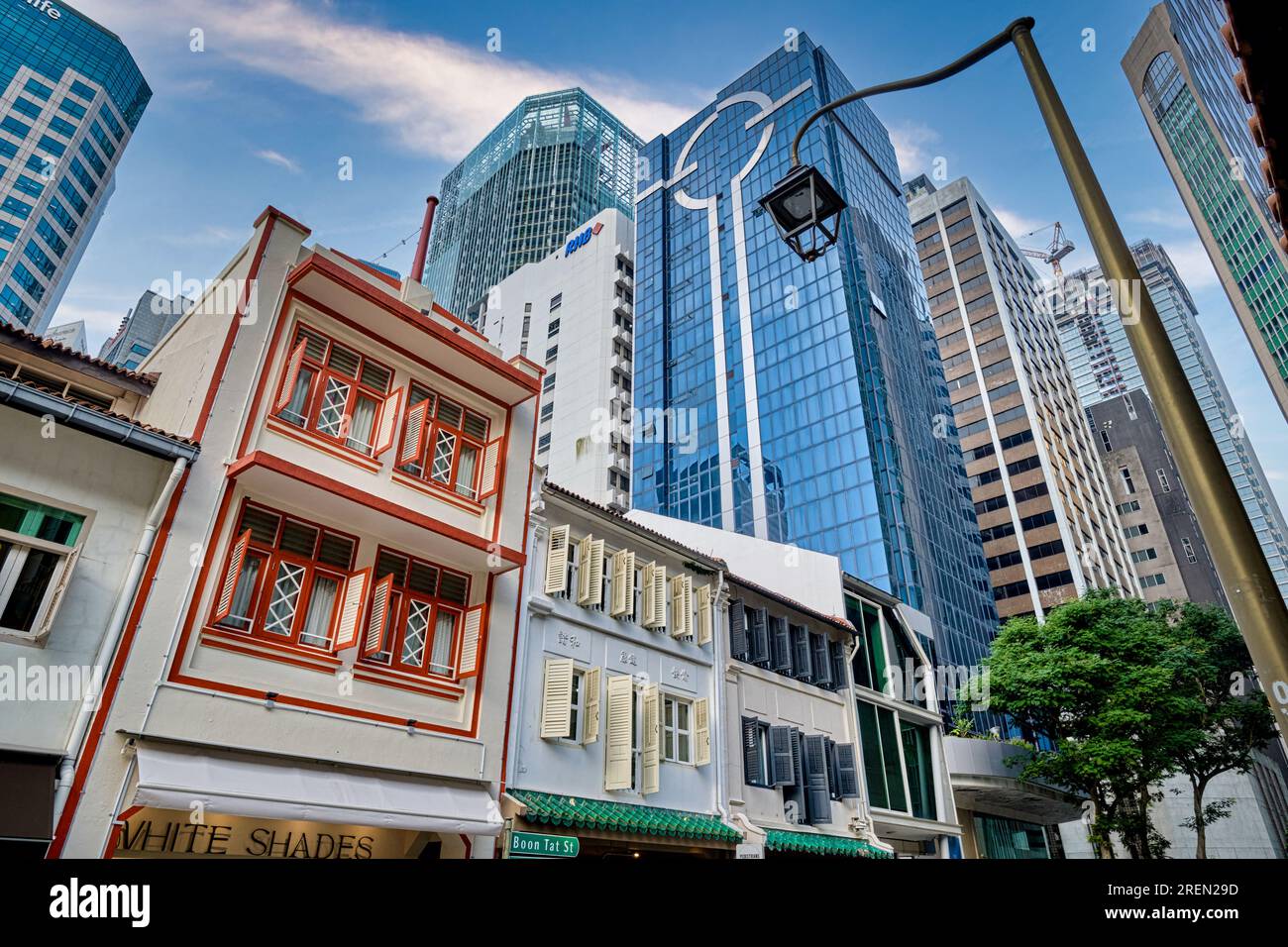 Traditional-style old Chinese shophouses in Boon Tat St., Chinatown, Singapore, with towering high rise office towers in the background Stock Photo