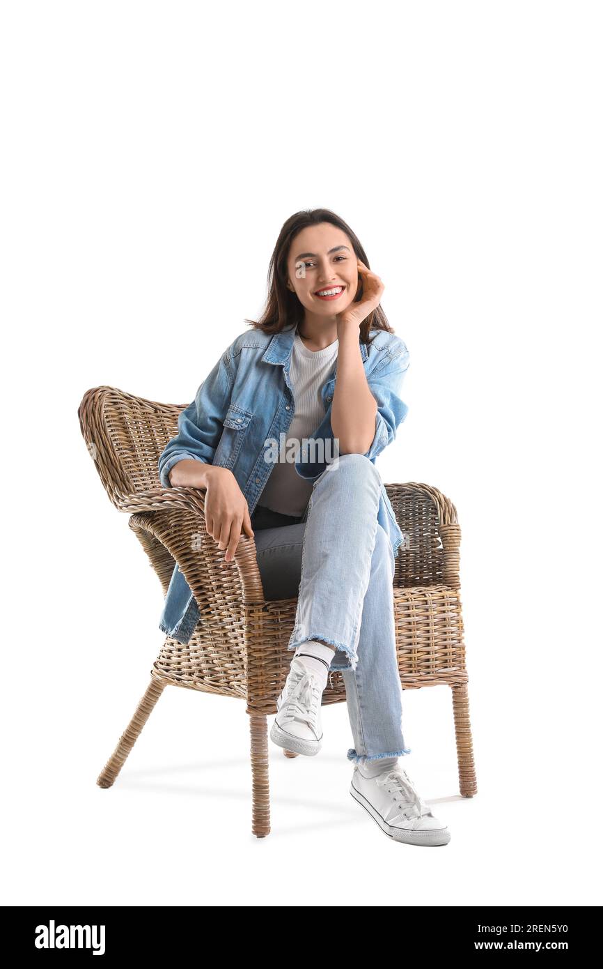 Young woman sitting in wicker armchair on white background Stock Photo ...
