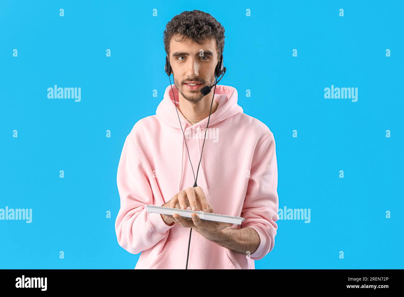 Male technical support agent with PC keyboard on blue background Stock ...