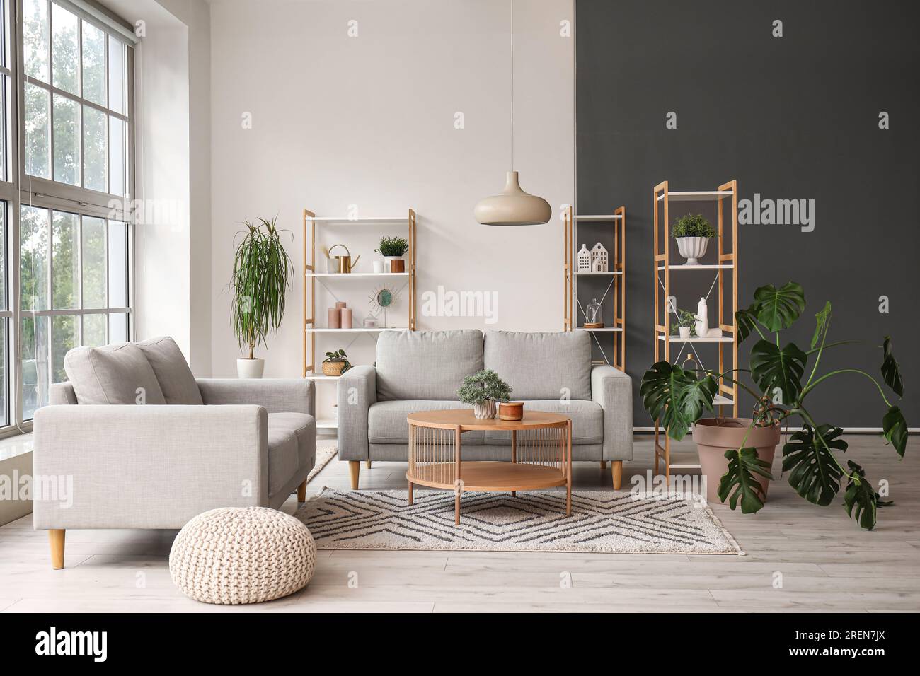 Interior of light living room with grey sofas, wooden coffee table and ...