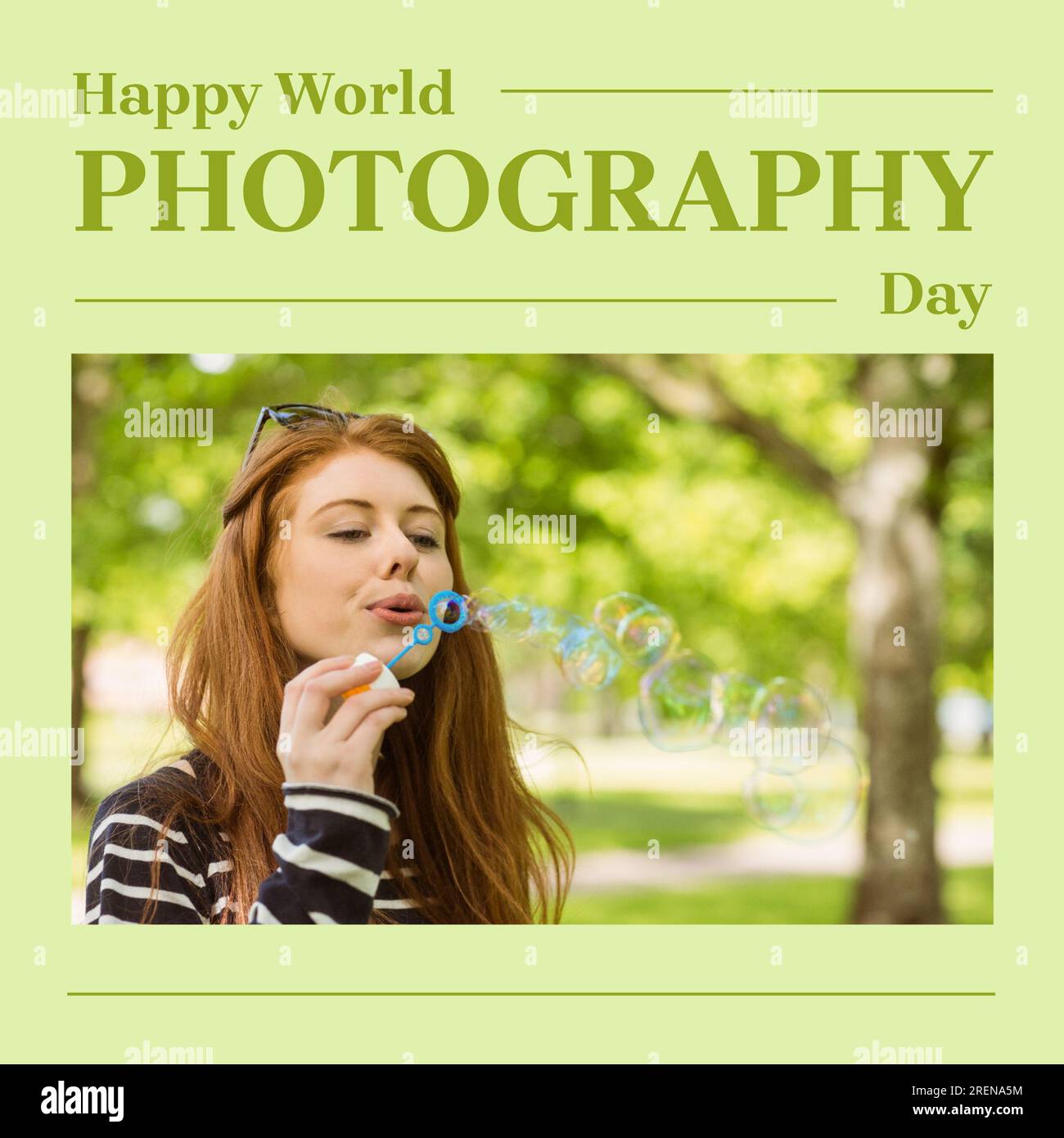 Happy world photography day text on green with happy caucasian woman blowing bubbles in park Stock Photo