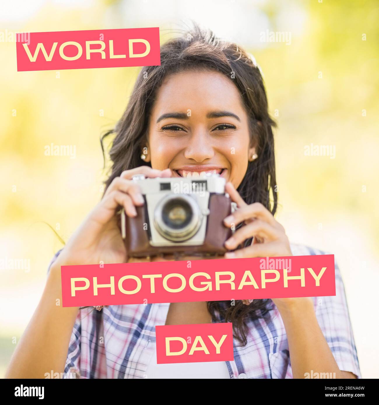 World photography day text on red over happy biracial woman holding outdoors in sun Stock Photo