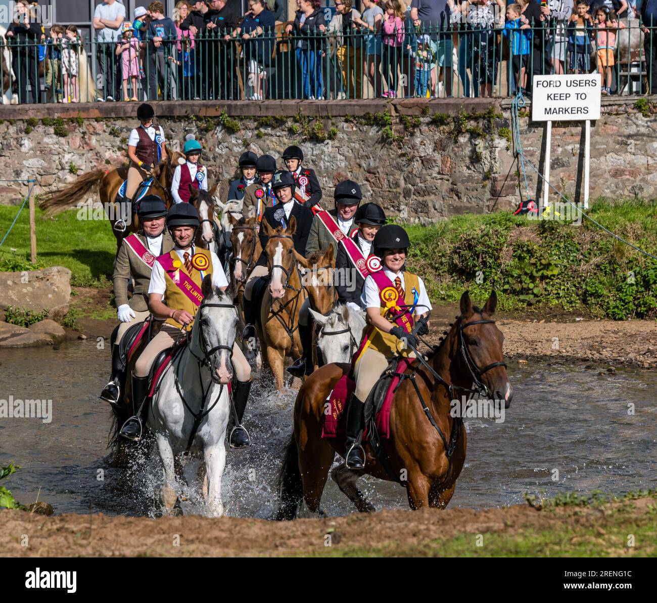 Musselburgh, East Lothian, Scotland, UK,  29th July 2023.. Musselburgh Festival: the week long festival culminates in the Festival Day Rideout with horse riders riding on a route through the town. Pictured: the riders ford the River Esk at the Roman Bridge. Credit: Sally Anderson/Alamy Live News Stock Photo