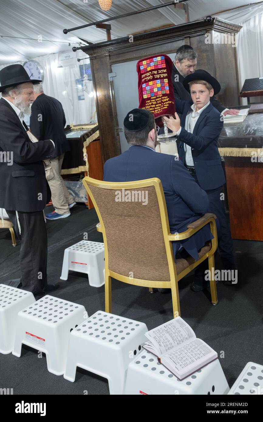 On Tisha B'av, at the conclusion of the Torah reading, the holy scroll is covered then returned to the ark. In Monsey, New York. Stock Photo