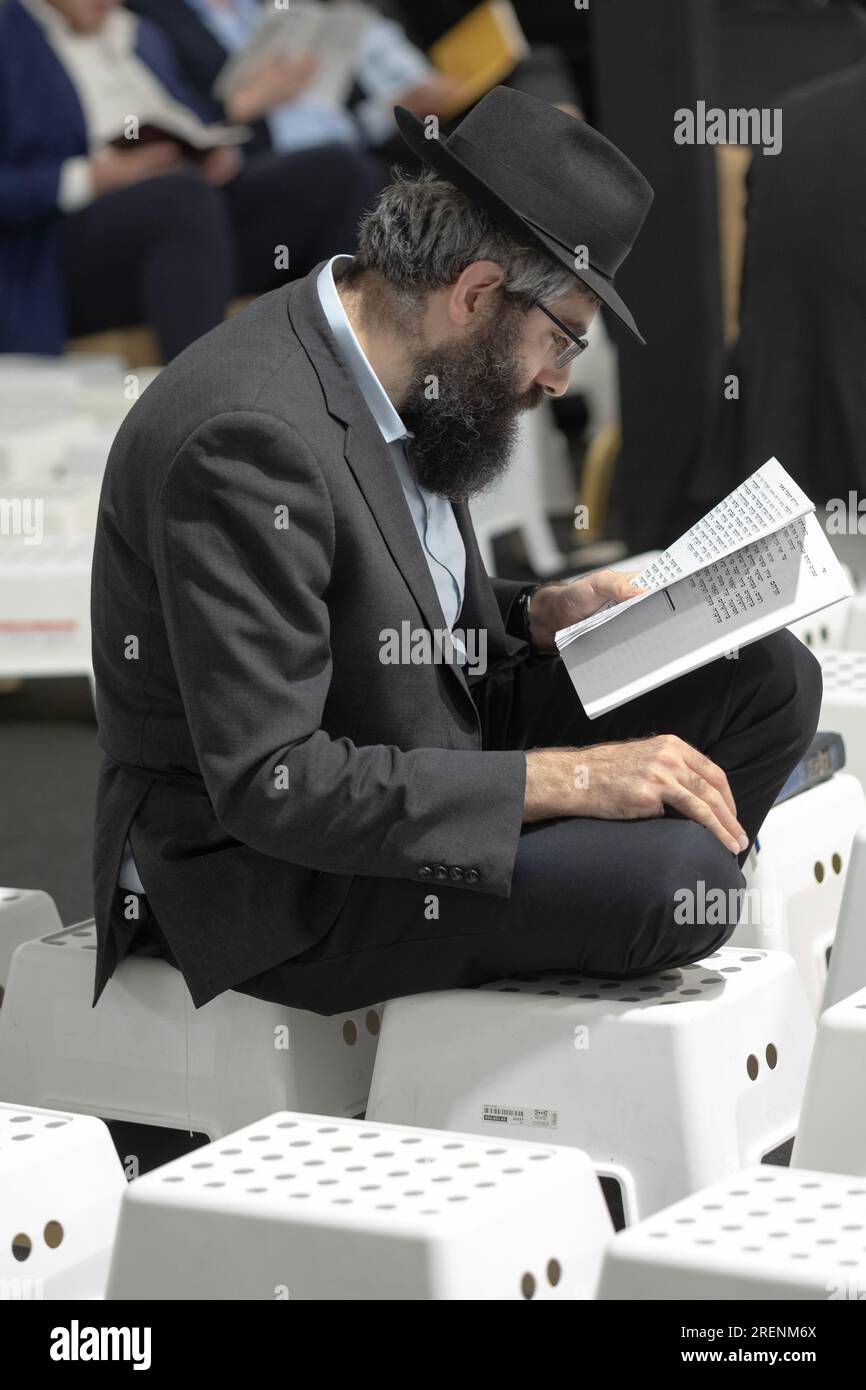 At Tish B'Av morning services, an orthodox Jewish men sit on low stools commensurate with the mourning laws for the day. In Rockland County, NY Stock Photo