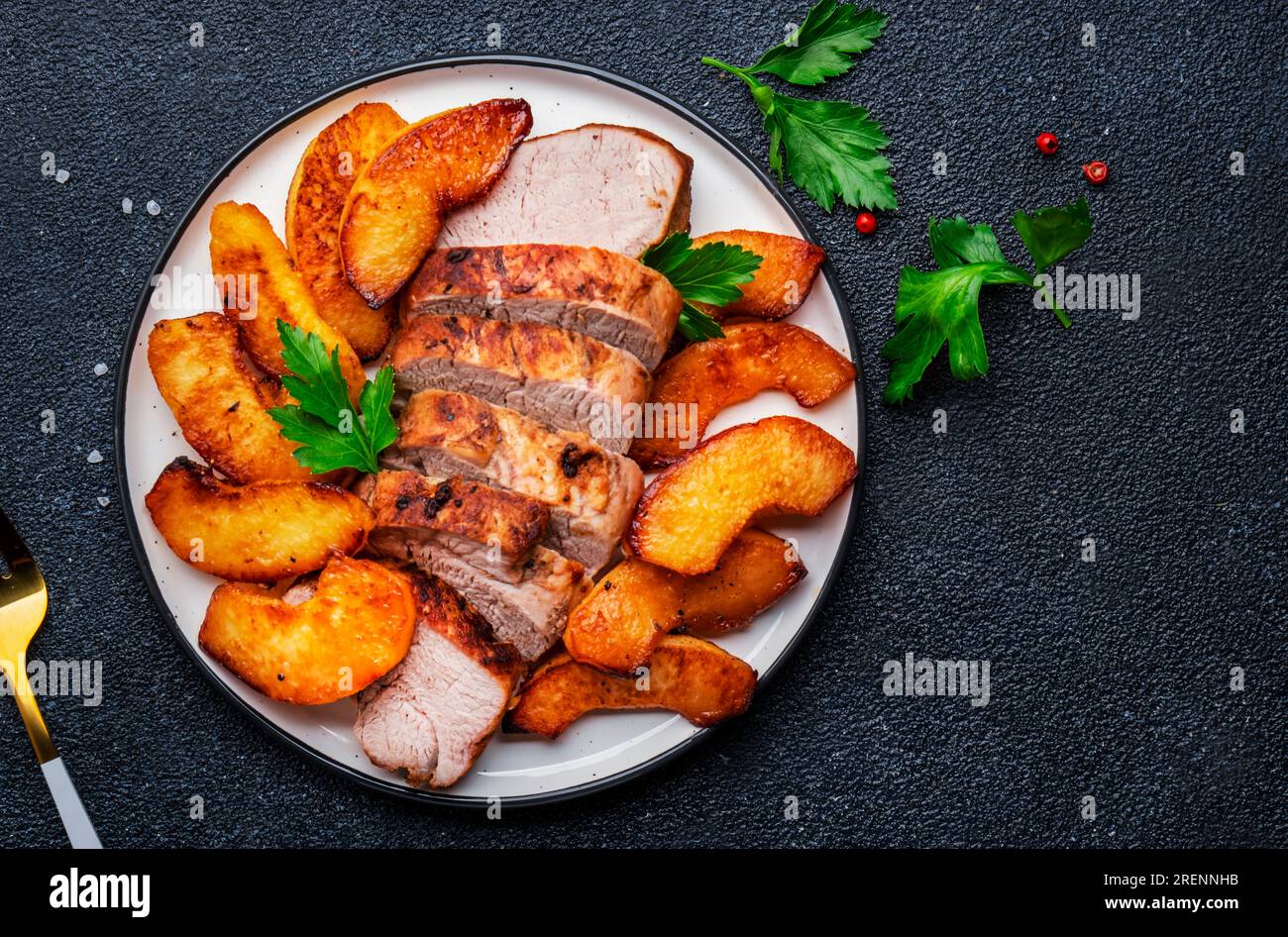Baked pork tenderloin with sweet quince or apple slices served on white