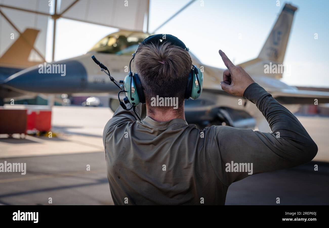 Airman 1st Class signals to F16 Falcon before takeoff, July 10, 2023
