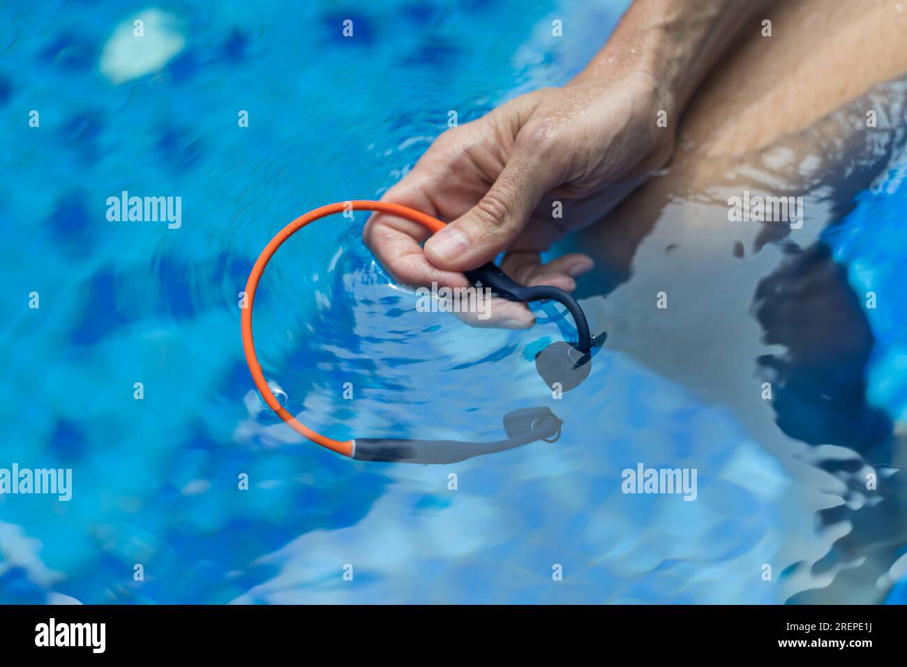 Waterproof audio device submerged in water. Headphones with bone
