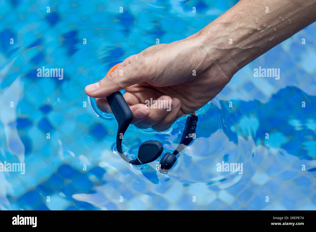 Waterproof audio device submerged in water. Headphones with bone