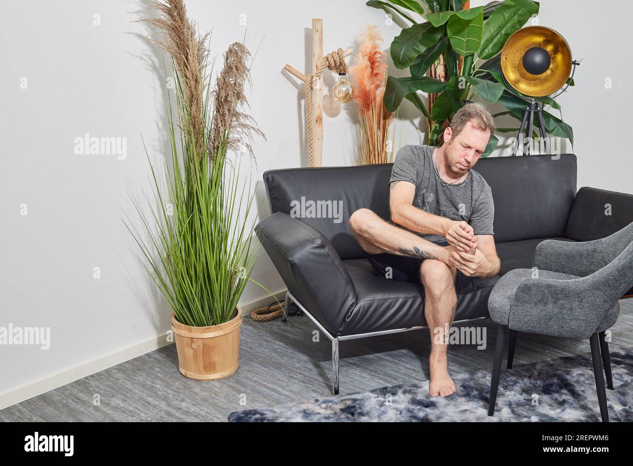 Young guy sitting home barefoot hi-res stock photography and images - Alamy
