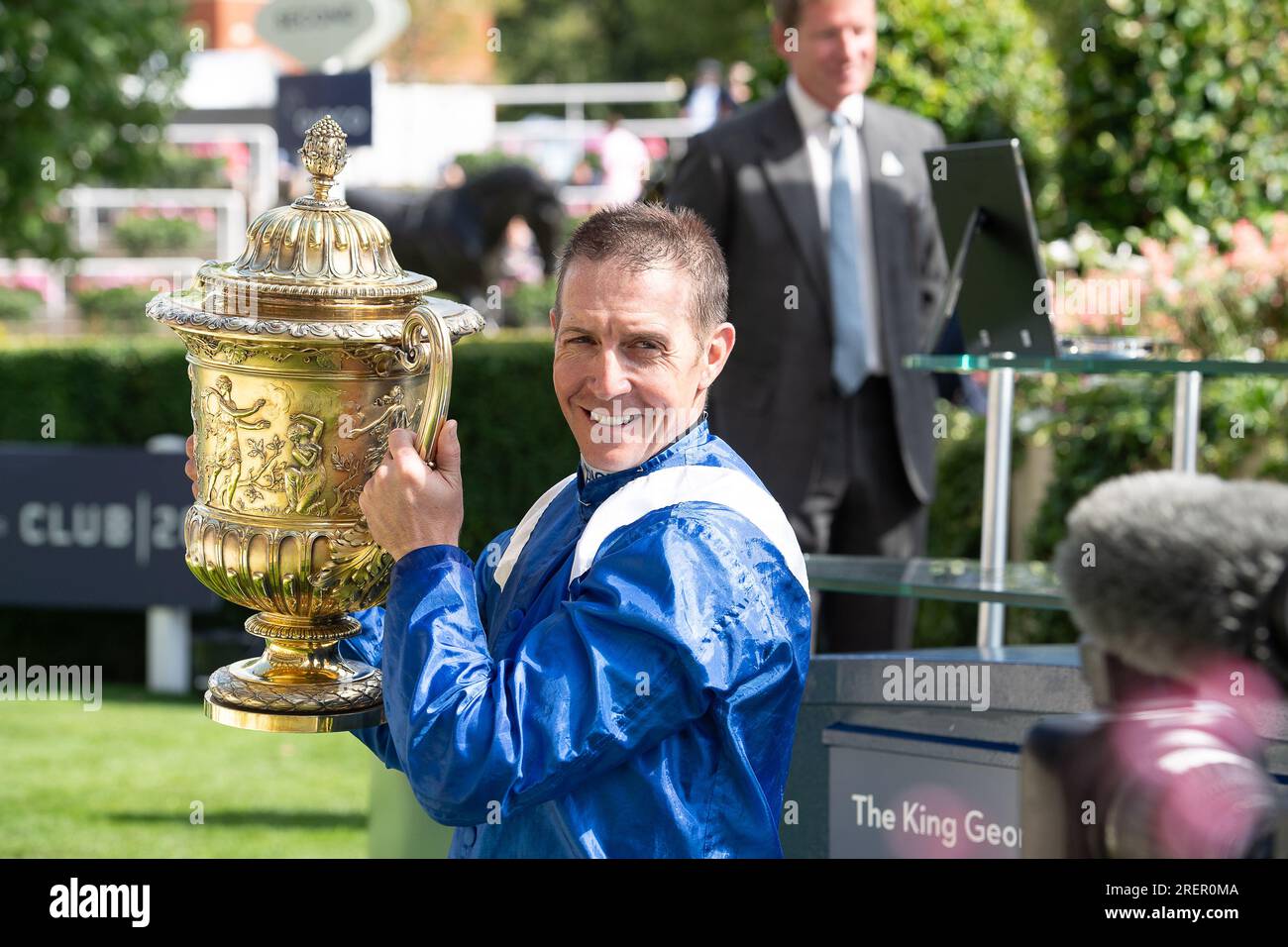 Ascot, Berkshire, UK. 29th July, 2023. Jim Crowley holds up the trophy after winning the King George race. Princess Anne, The Princess Royal made the presentation to owners, trainer and jockey for the King George VI and Queen Elizabeth QIPCO Stakes. The race was won by horse Hukum ridden by jockey Jim Crowley. Sheikha Hissa, and her husband Sheikh Maktoum bin Majid Al Maktoum received the trophy from the Princess Royal. Owners and Breeder Shadwell Estate Company Ltd. Trainer Owen Burrows, Lambourn. Credit: Maureen McLean/Alamy Live News Stock Photo