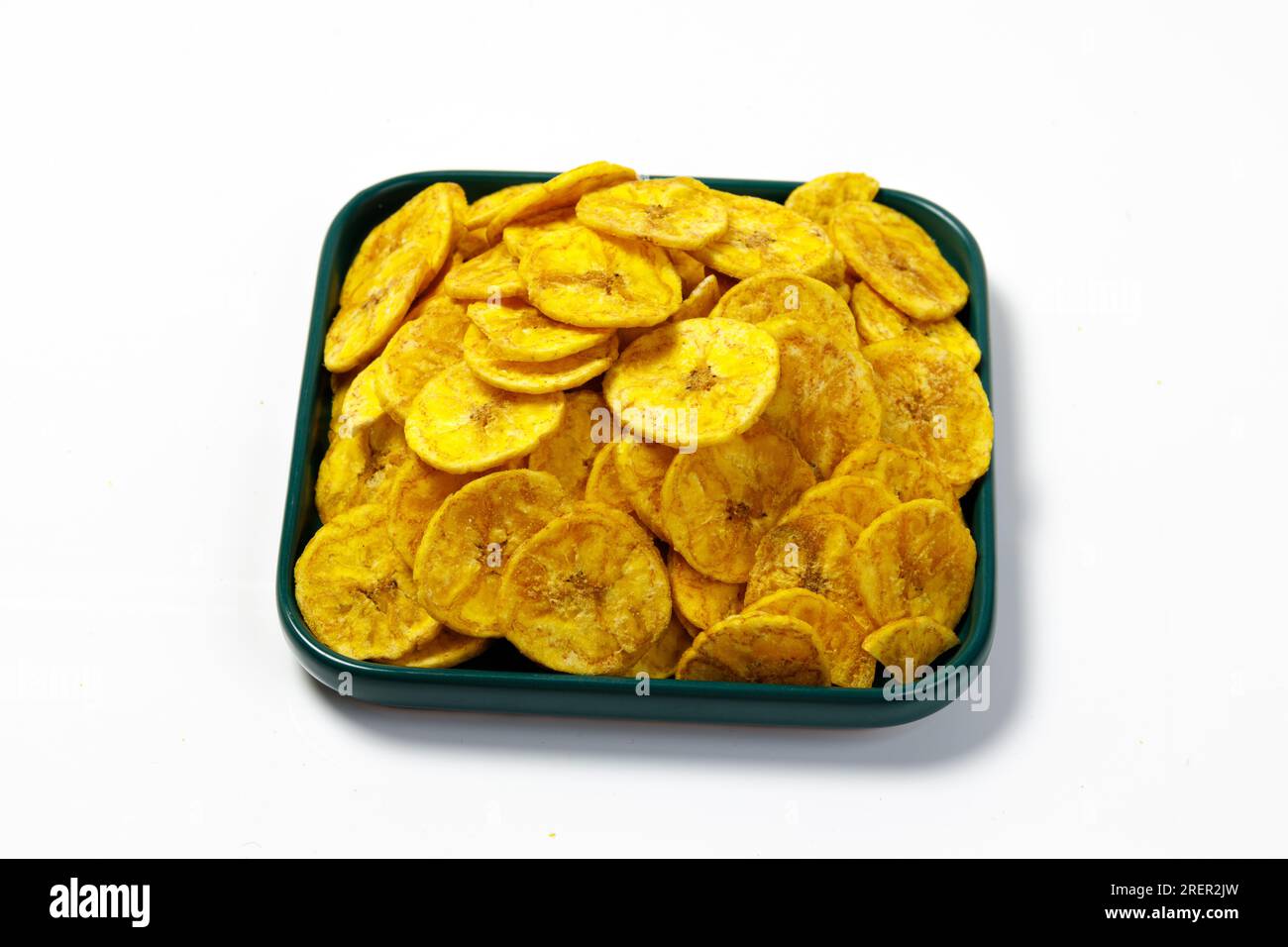 Kerala chips or Banana chips, cult snack item of Kerala, arranged in a green ceramic square shaped plate ,Isolated image with white background Stock Photo