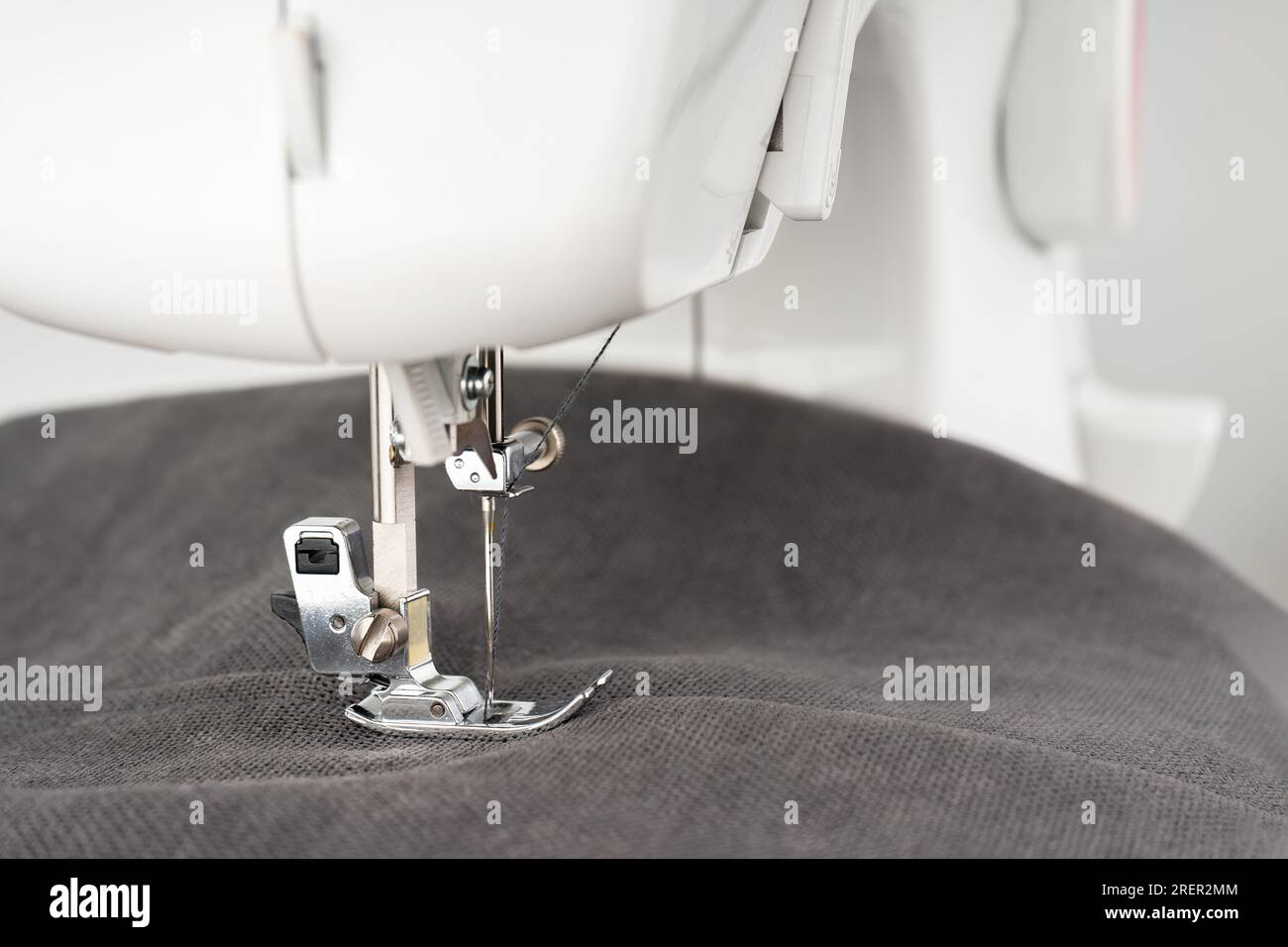 Modern sewing machine with gray fabric and. Sewing process clothes, curtains, upholstery