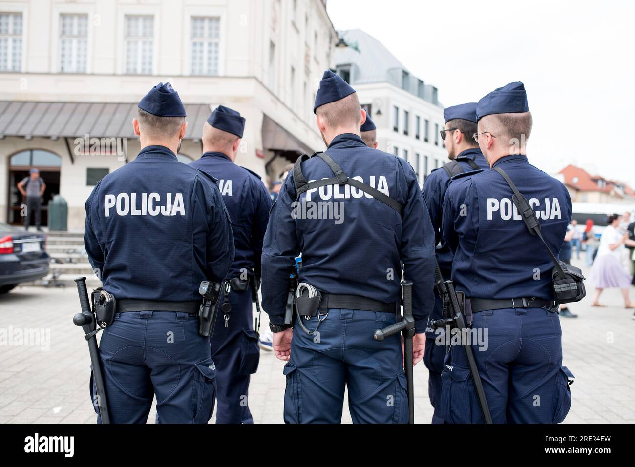 Polish policemen stand with their backs to the camera. Stock Photo