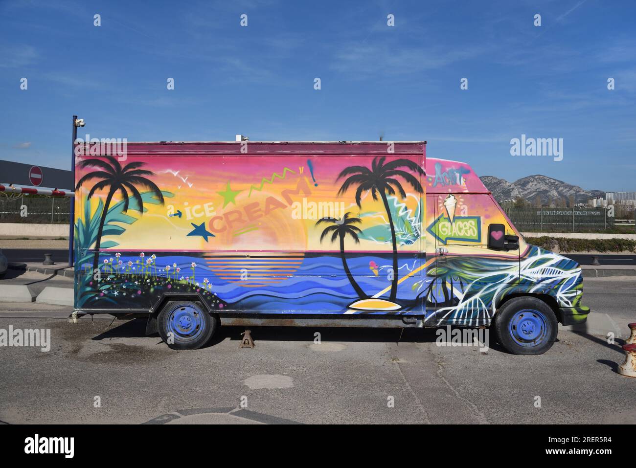 Customised Ice Cream Van Painted with Exotic Beach Scene with Palm Trees and Sunset or Setting Sun Prado Beach Marseille France Stock Photo