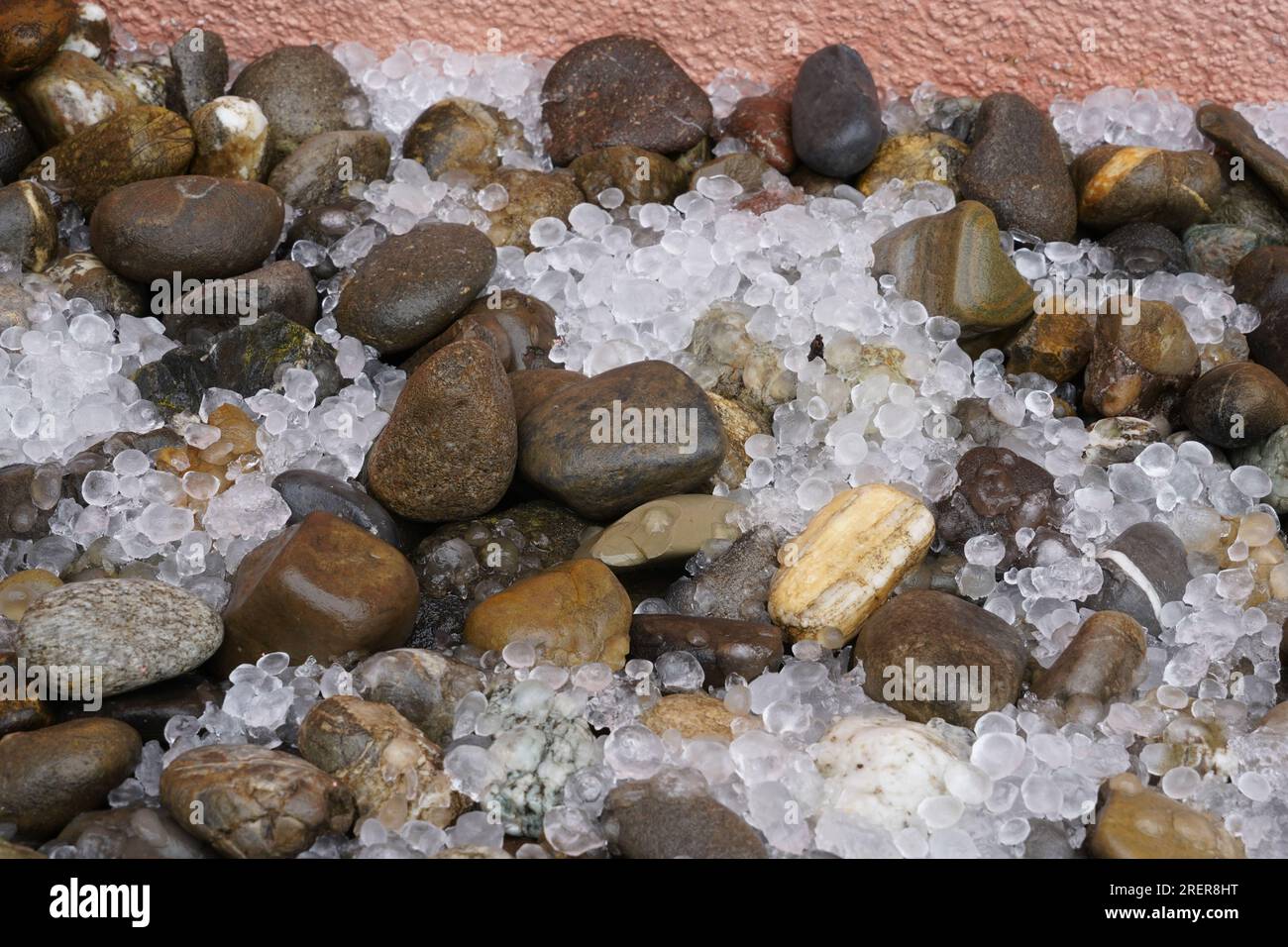 Hailstones spread on the ground with decorative stones. Stock Photo
